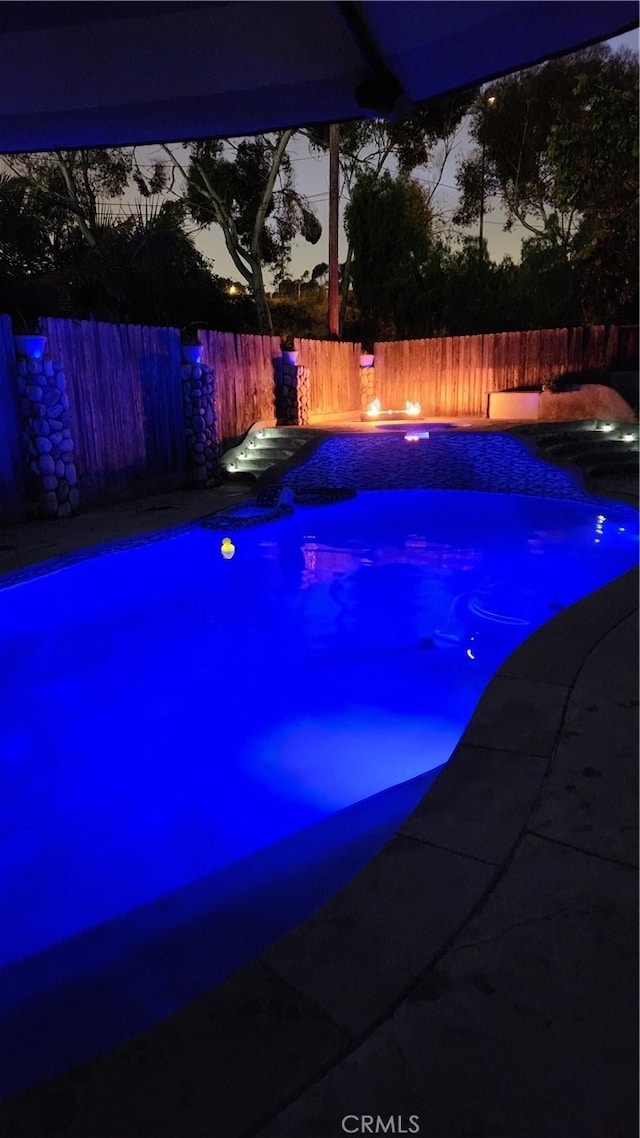 view of pool at dusk