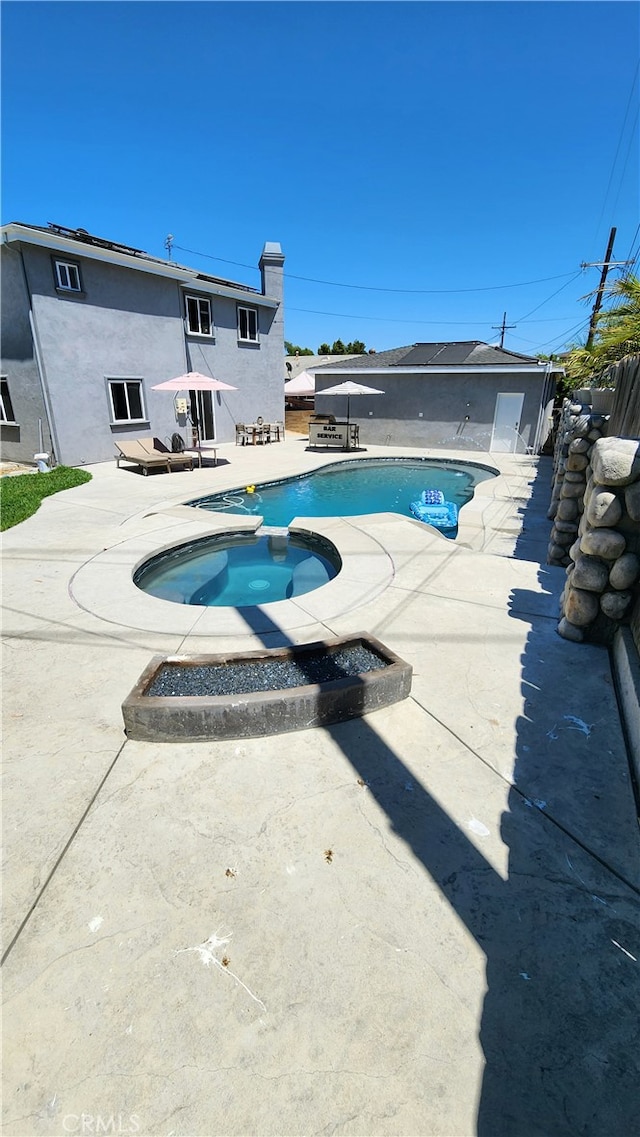 view of pool with a patio and an in ground hot tub