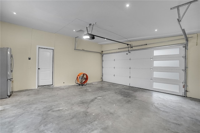 garage featuring stainless steel fridge and a garage door opener