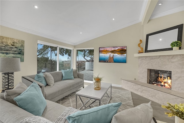 living room with a high end fireplace, vaulted ceiling, and ornamental molding