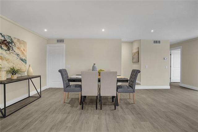 dining area with ornamental molding and light wood-type flooring