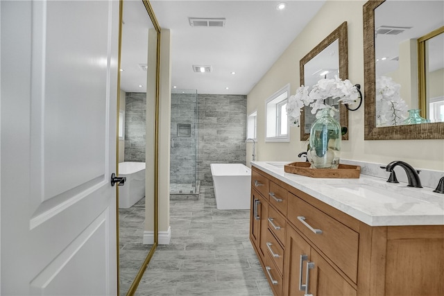 bathroom featuring vanity and independent shower and bath