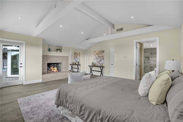 bedroom with vaulted ceiling with beams, a premium fireplace, and light hardwood / wood-style flooring