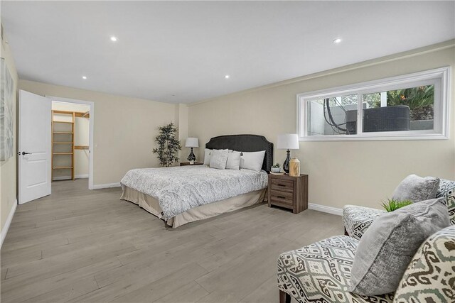 bedroom featuring light hardwood / wood-style flooring, a spacious closet, and a closet