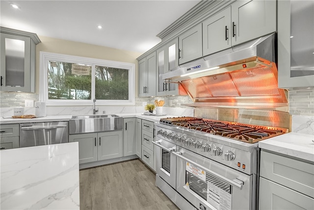 kitchen with decorative backsplash, appliances with stainless steel finishes, and light stone counters