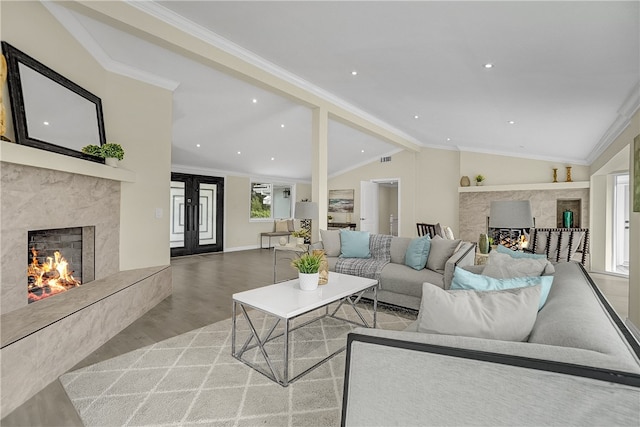 living room with a high end fireplace, french doors, lofted ceiling with beams, crown molding, and light hardwood / wood-style floors