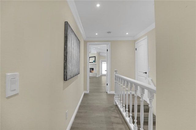 hall with light hardwood / wood-style floors and crown molding