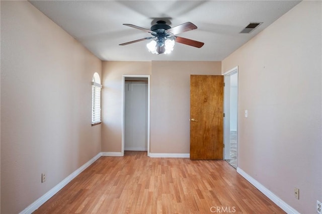 unfurnished bedroom featuring a ceiling fan, visible vents, baseboards, a closet, and light wood-type flooring