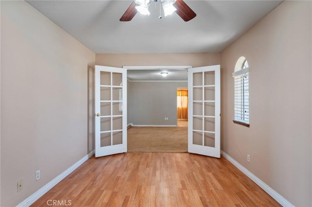 unfurnished room featuring light wood finished floors, baseboards, and french doors