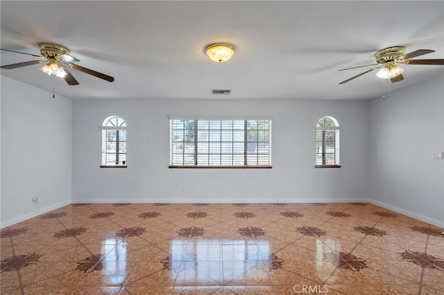 spare room with ceiling fan and plenty of natural light