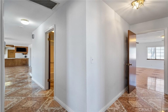 hallway featuring visible vents and baseboards