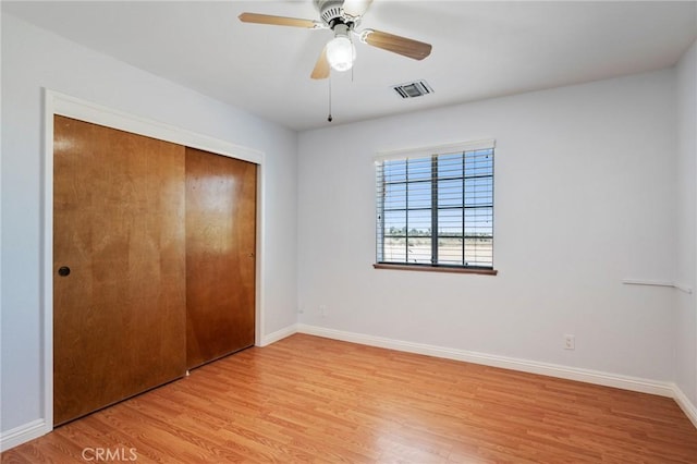 unfurnished bedroom with light hardwood / wood-style flooring, a closet, and ceiling fan