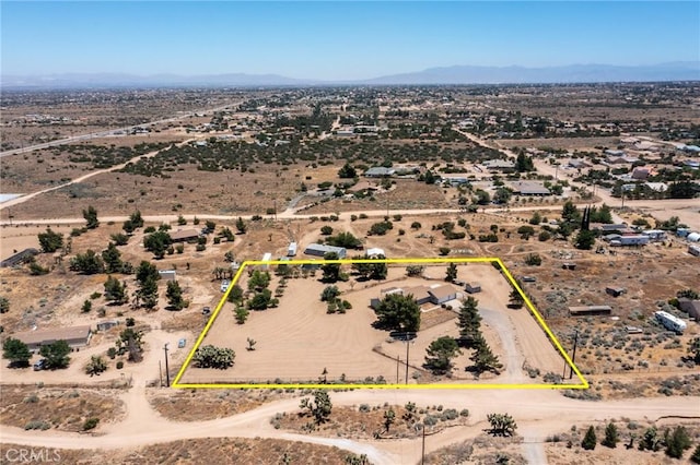 drone / aerial view featuring a mountain view and view of desert