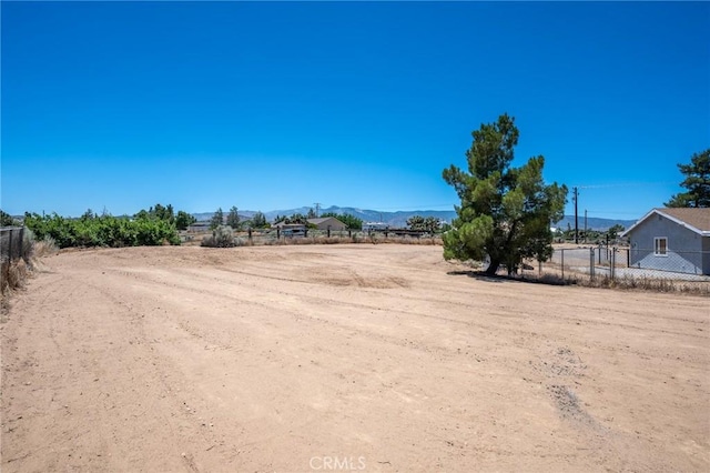 view of yard featuring fence and a mountain view