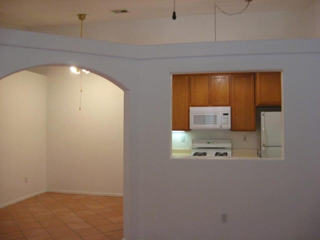 kitchen featuring white appliances and light tile patterned flooring