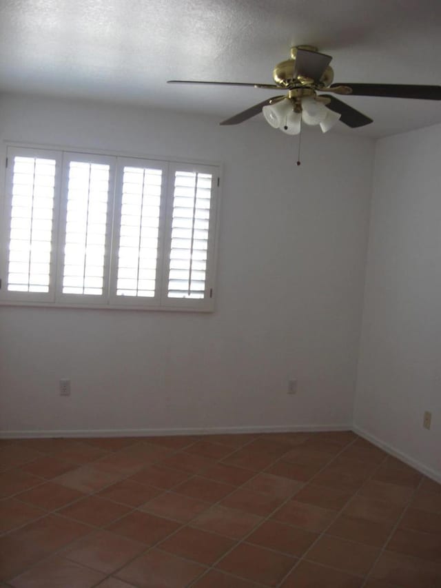 empty room featuring ceiling fan and tile patterned floors