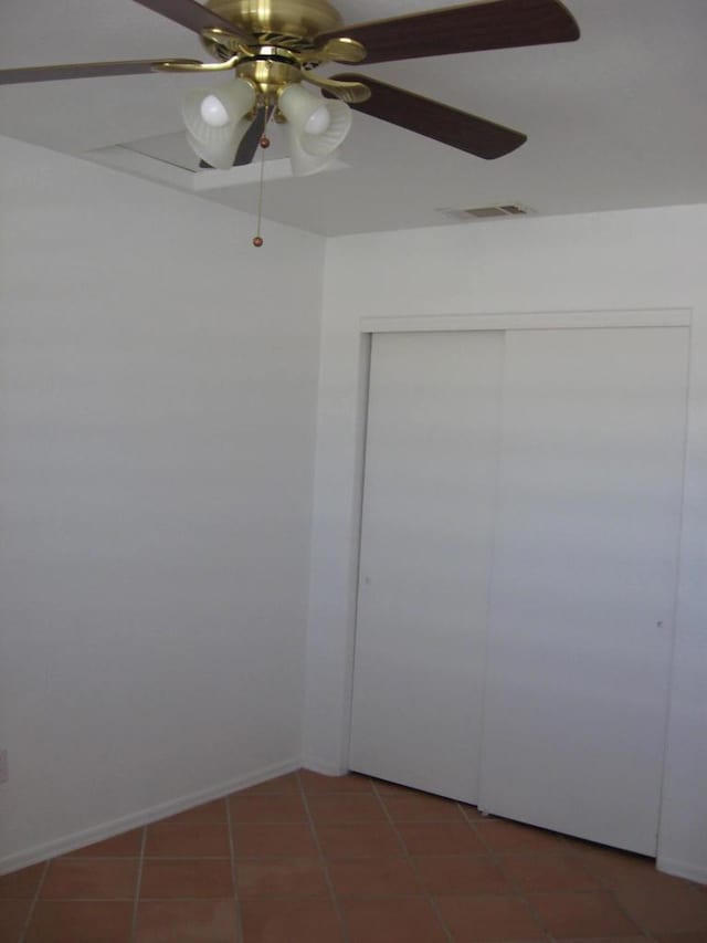 interior space featuring ceiling fan and dark tile patterned flooring