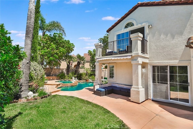 view of yard featuring a swimming pool with hot tub, a balcony, a patio area, and outdoor lounge area