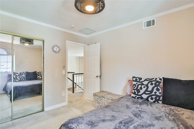 carpeted bedroom featuring crown molding and a closet