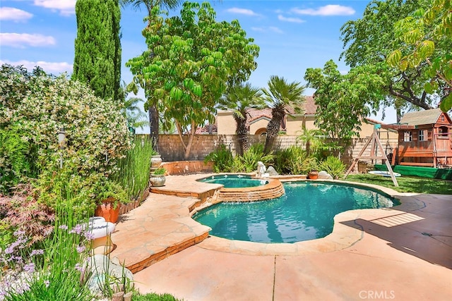 view of pool with an in ground hot tub and a playground