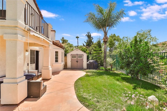 view of yard with a balcony, a shed, and a patio