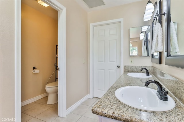 bathroom with tile patterned floors, double sink vanity, and toilet