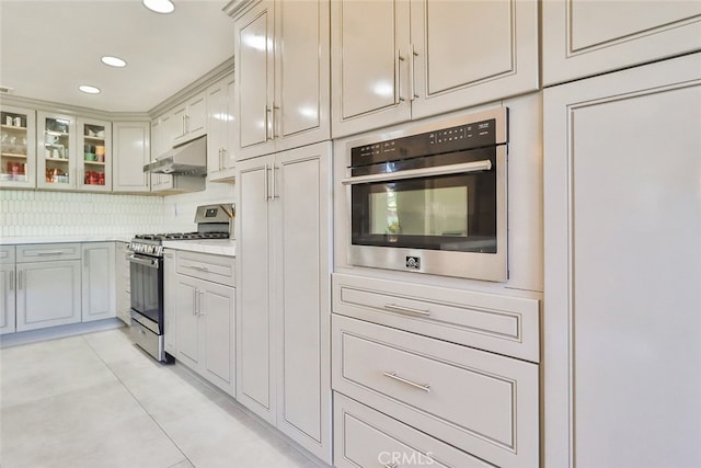 kitchen featuring decorative backsplash, appliances with stainless steel finishes, and light tile patterned floors