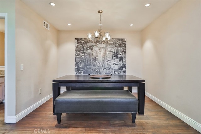 dining space with dark hardwood / wood-style floors and a notable chandelier