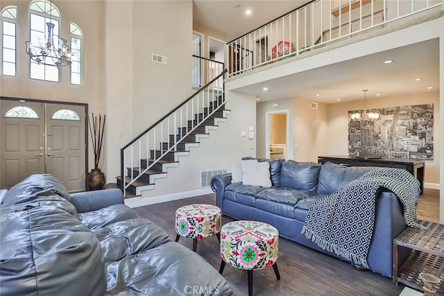 living room with a high ceiling, dark hardwood / wood-style floors, and a chandelier