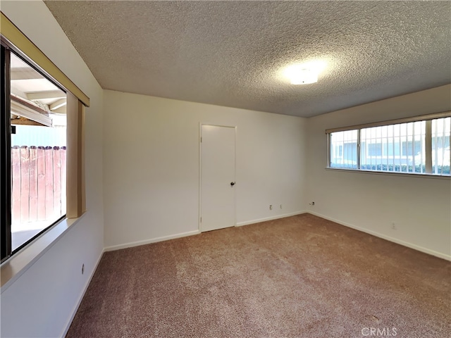 carpeted spare room featuring a textured ceiling