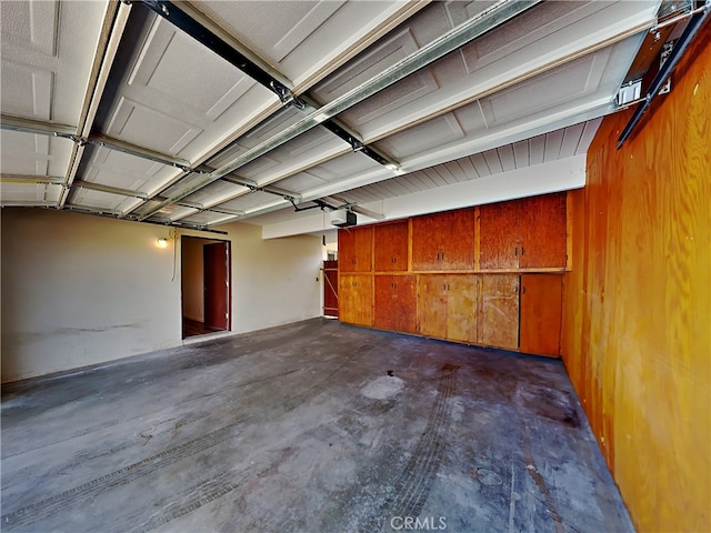 garage with a garage door opener and wooden walls