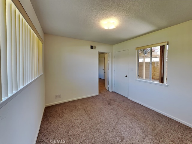 spare room with carpet floors and a textured ceiling