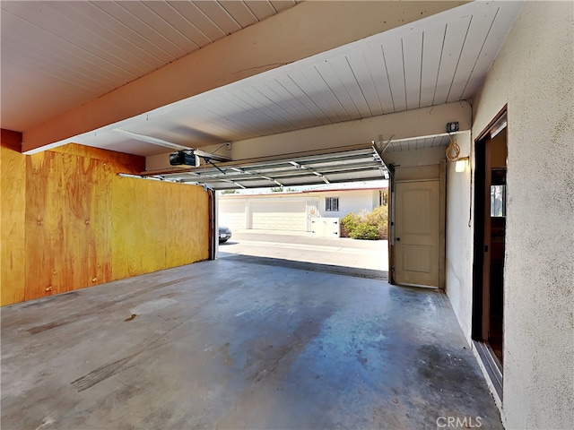 garage featuring wood walls and a garage door opener