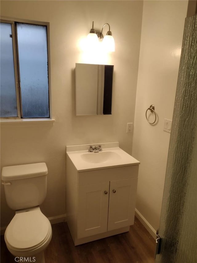 bathroom featuring toilet, hardwood / wood-style flooring, and vanity