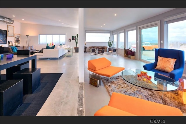 living room with vaulted ceiling and concrete floors