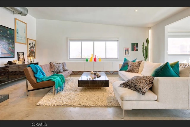 living room featuring concrete floors and vaulted ceiling