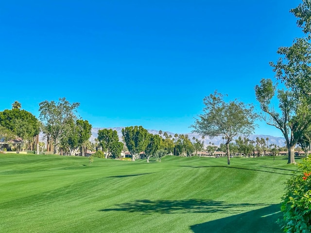 surrounding community with a yard and a mountain view