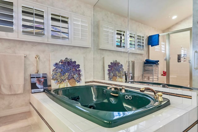 bathroom featuring independent shower and bath, vaulted ceiling, and tile patterned floors