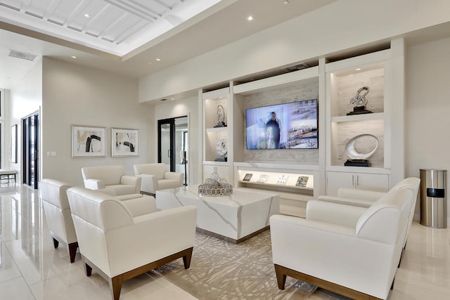 tiled living room with built in shelves and a high ceiling