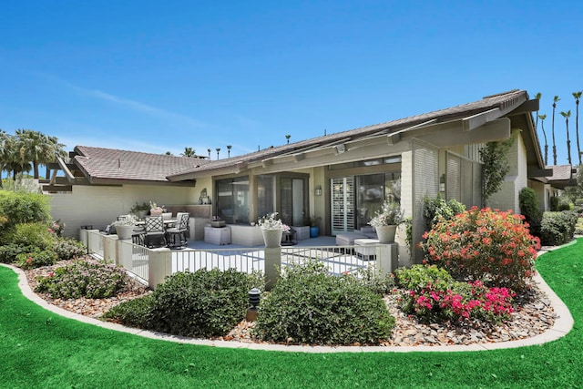 rear view of property featuring an outdoor living space and a yard