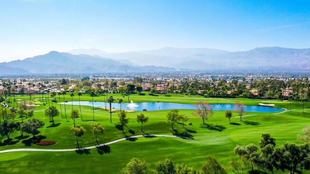 view of home's community featuring a water and mountain view and a yard