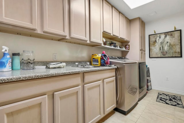 laundry area with light tile patterned floors, washing machine and clothes dryer, and cabinets