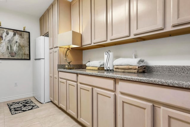 kitchen featuring light brown cabinetry and white refrigerator