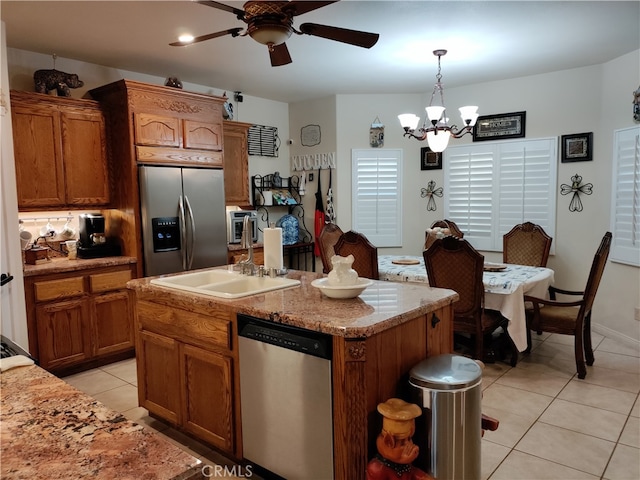 kitchen with sink, an island with sink, ceiling fan with notable chandelier, appliances with stainless steel finishes, and decorative light fixtures