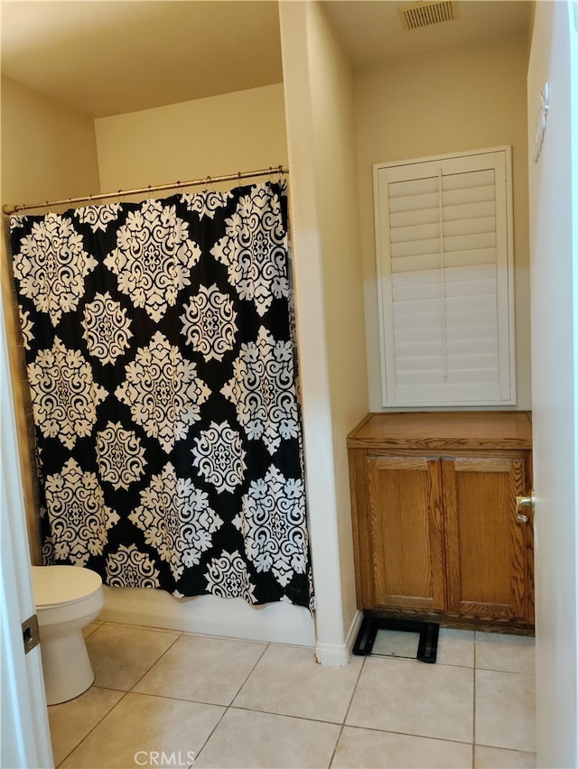 bathroom featuring a shower with curtain, tile patterned floors, and toilet