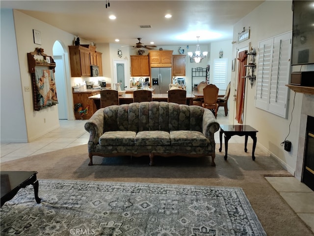 living room featuring ceiling fan with notable chandelier and light tile patterned floors