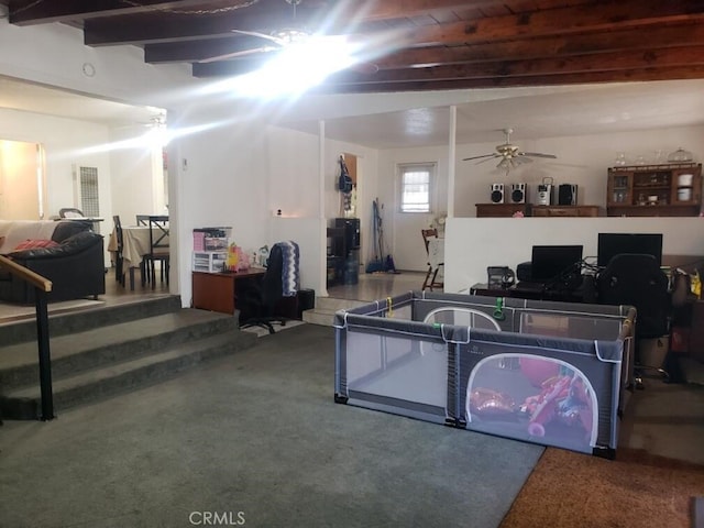 interior space featuring beamed ceiling, carpet, and ceiling fan