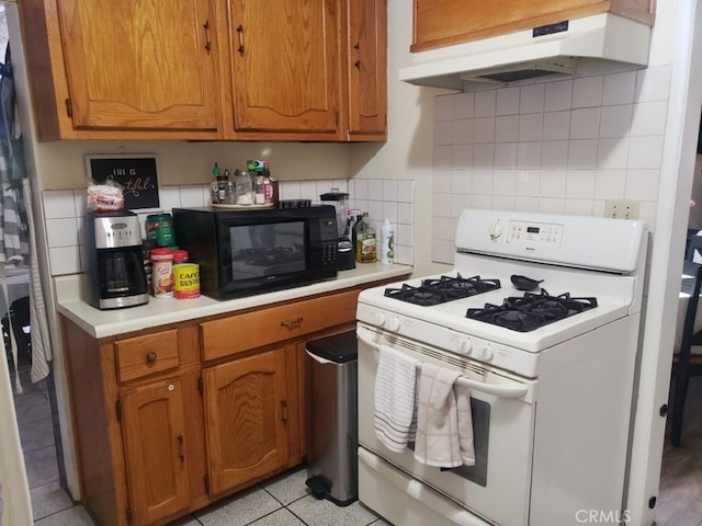 kitchen with white range with gas cooktop, tasteful backsplash, and extractor fan