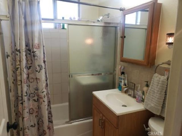 full bathroom with vanity, shower / bath combo with shower curtain, and toilet