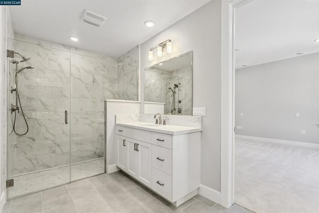 bathroom featuring vanity, tile patterned floors, and tiled shower